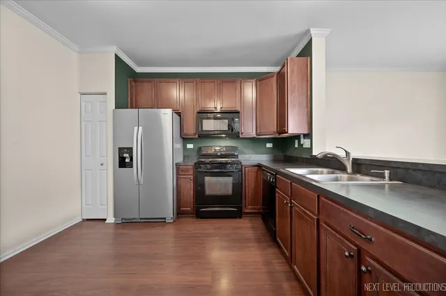 a kitchen with stainless steel appliances granite countertop a refrigerator stove and sink