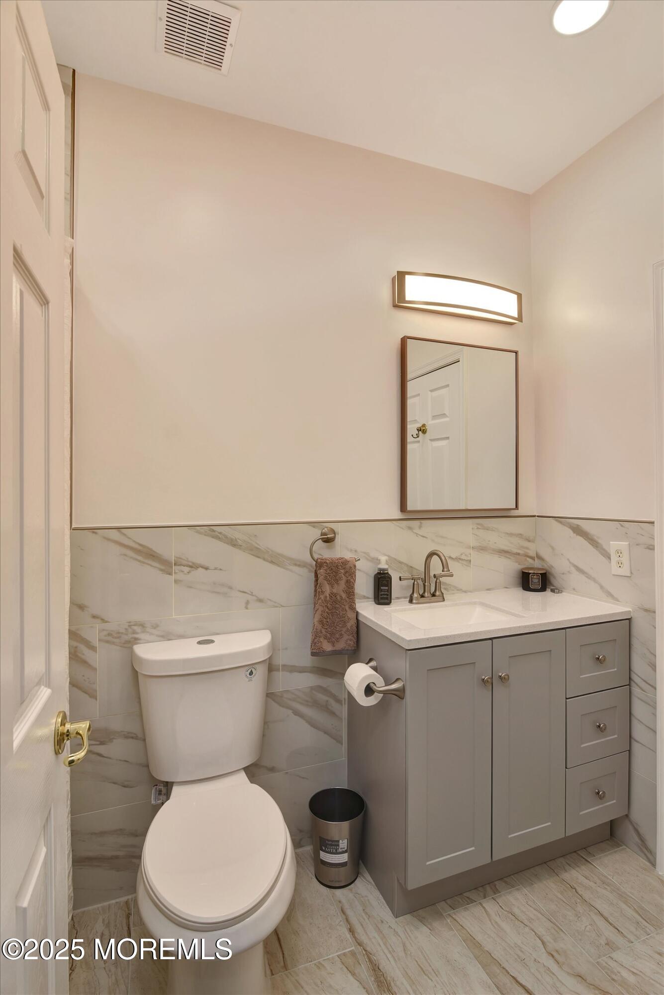 594 St Andrews Place Manalapan, NJ 07726 - Photo 20 of 35 a bathroom with a toilet sink and mirror