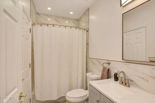a bathroom with a sink vanity mirror and toilet