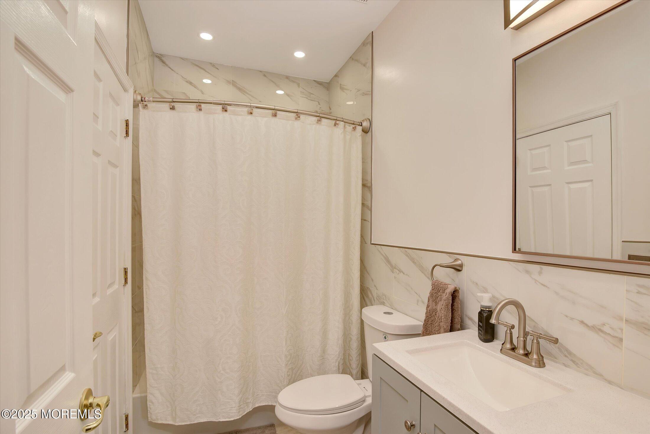 594 St Andrews Place Manalapan, NJ 07726 - Photo 23 of 35 a bathroom with a sink vanity mirror and toilet