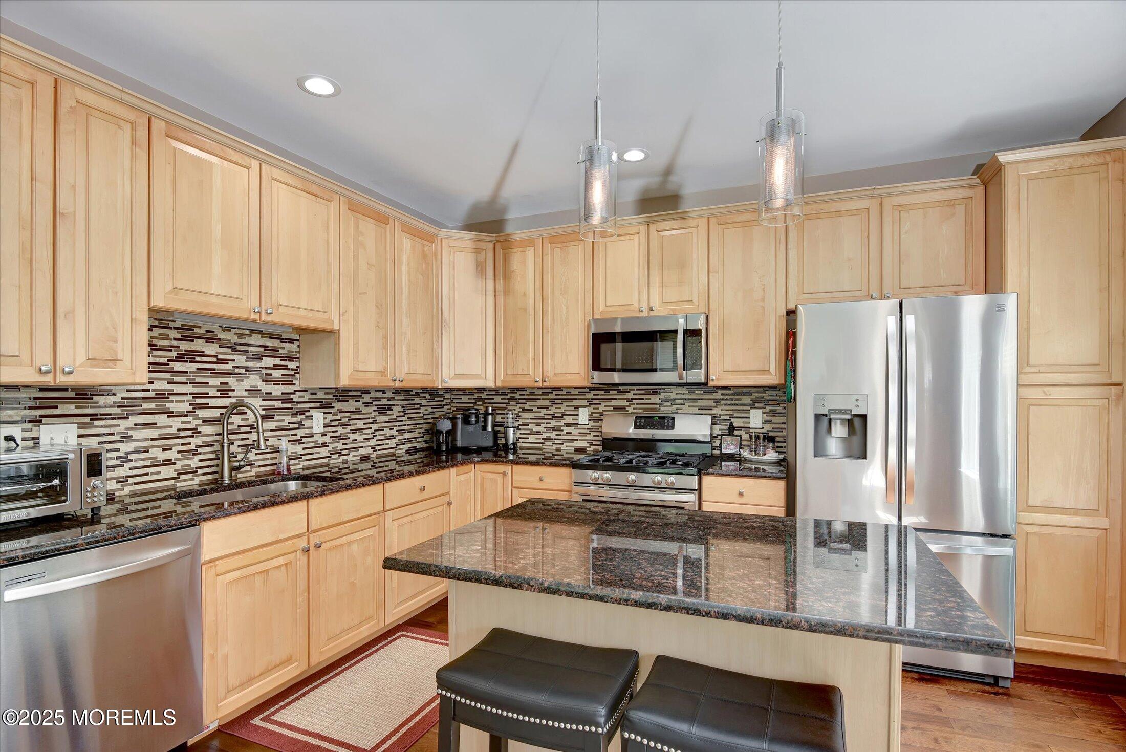 594 St Andrews Place Manalapan, NJ 07726 - Photo 3 of 35 a kitchen with white cabinets and stainless steel appliances