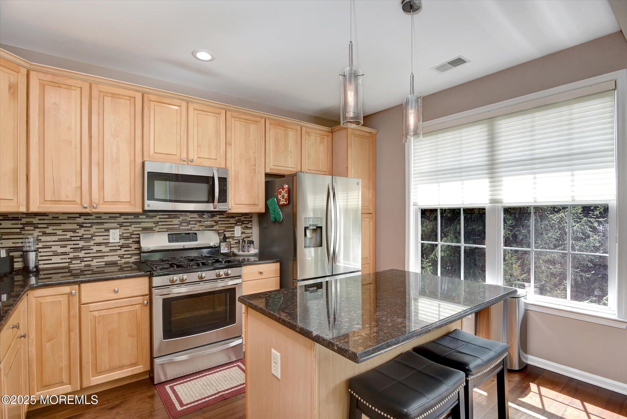 594 St Andrews Place Manalapan, NJ 07726 - Photo 5 of 35 a kitchen with kitchen island granite countertop a stove a sink and a refrigerator