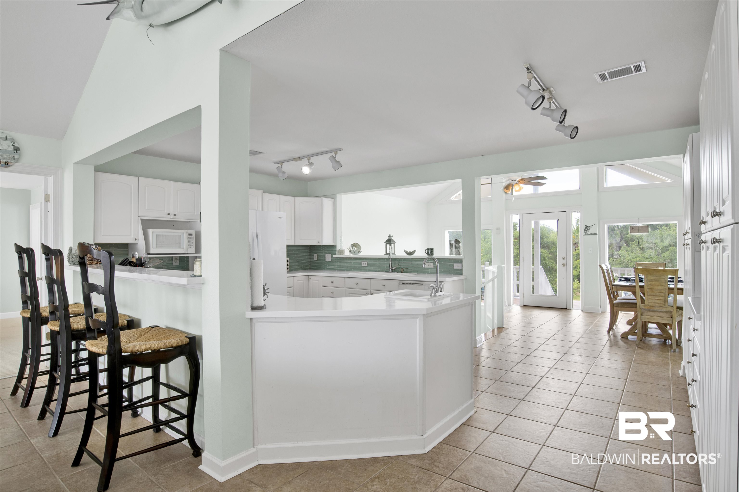 33093 River Road Orange Beach, AL 36561 - Photo 9 of 30 Kitchen featuring white appliances, rail lighting, kitchen peninsula, white cabinets, and ceiling fan