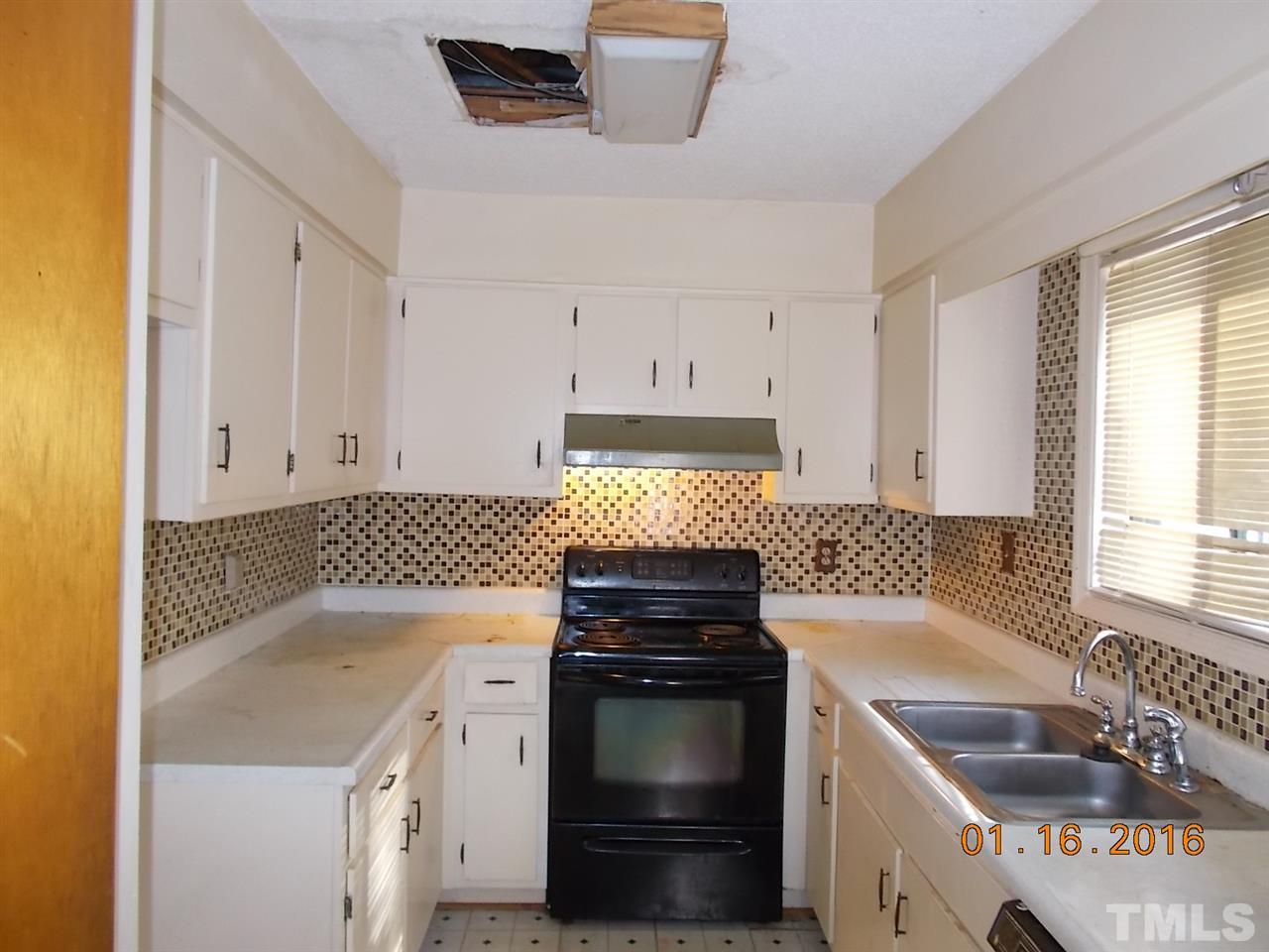 4313 Lake Ridge Drive, Unit 9E Raleigh, NC 27604 - Photo 3 of 16 a kitchen with granite countertop a sink and a stove top oven