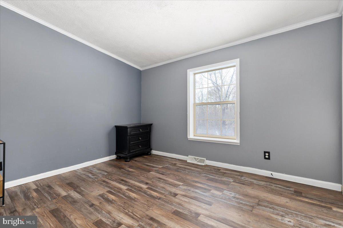 1501 South Timber Ridge Road Cross Junction, VA 22625 - Photo 17 of 66 a view of an empty room with wooden floor and a window