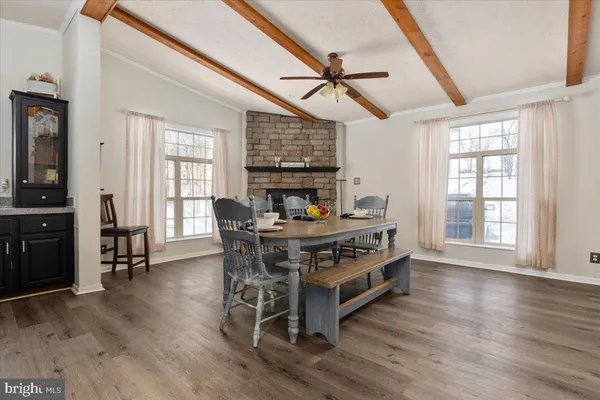 a living room with a table chairs and a wooden floor