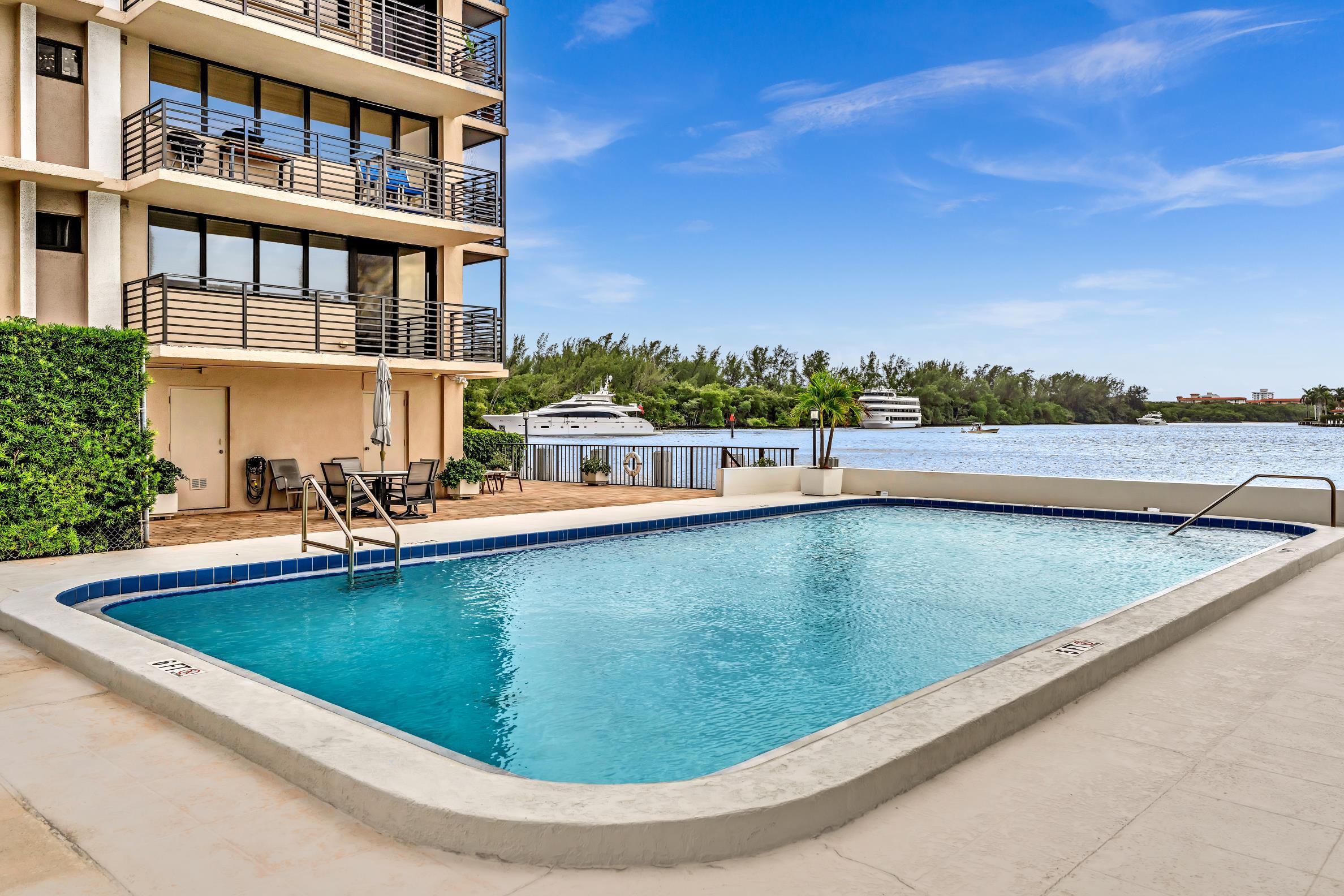 900 Northeast Spanish River Boulevard, Unit 4E Boca Raton, FL 33431 - Photo 21 of 26 a view of a swimming pool with a lounge chair
