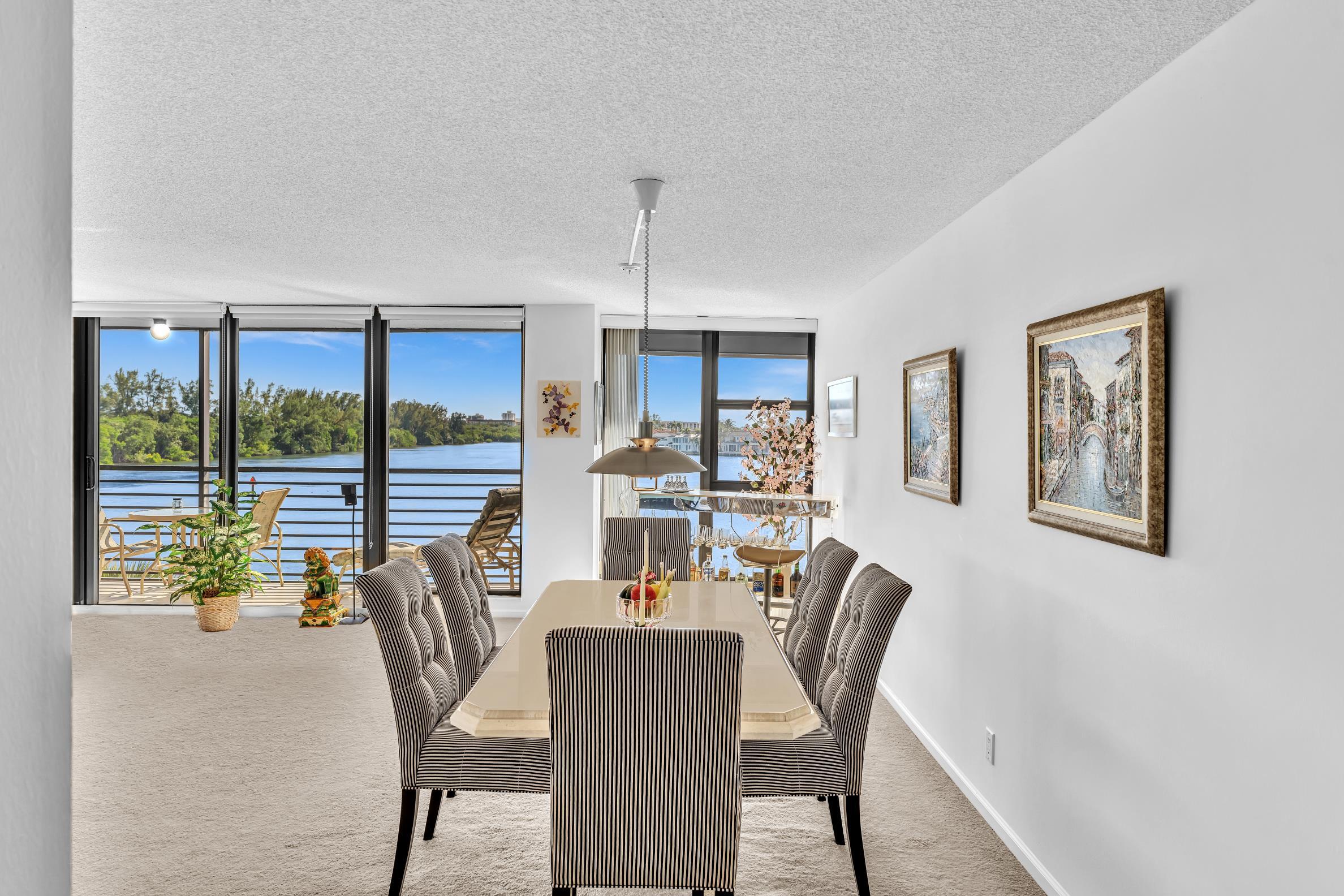 900 Northeast Spanish River Boulevard, Unit 4E Boca Raton, FL 33431 - Photo 6 of 26 a dining room with furniture a chandelier and wooden floor