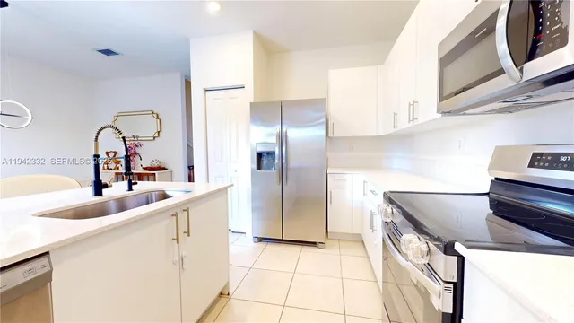 a kitchen with stainless steel appliances granite countertop a sink and a refrigerator