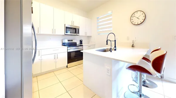 a kitchen with stainless steel appliances granite countertop a sink and a stove