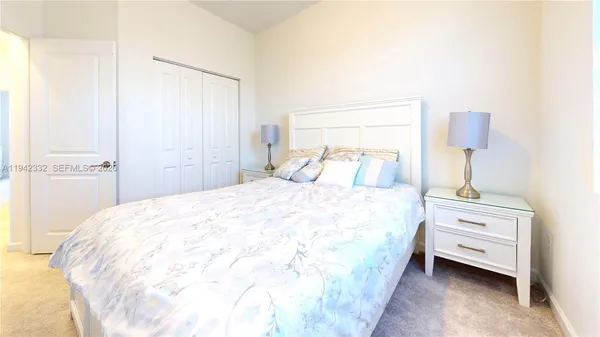 a large bed sitting in a bedroom next to a bathroom sink