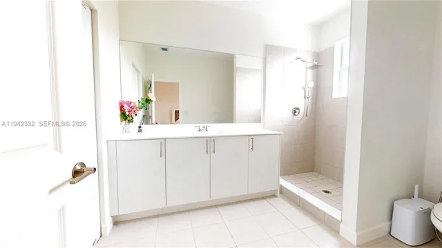 a bathroom with a double vanity sink toilet mirror and bathtub