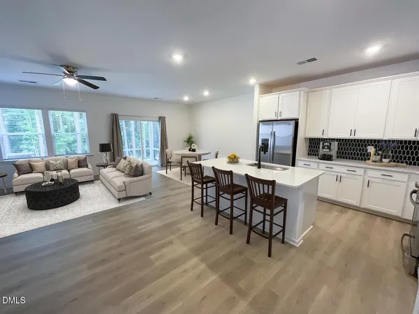 a living room with lots of furniture and kitchen view