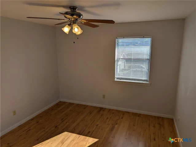 a view of a small space with wooden floor and a window