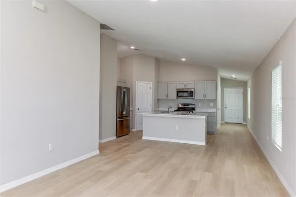 a kitchen with stainless steel appliances kitchen island granite countertop a refrigerator and a stove top oven