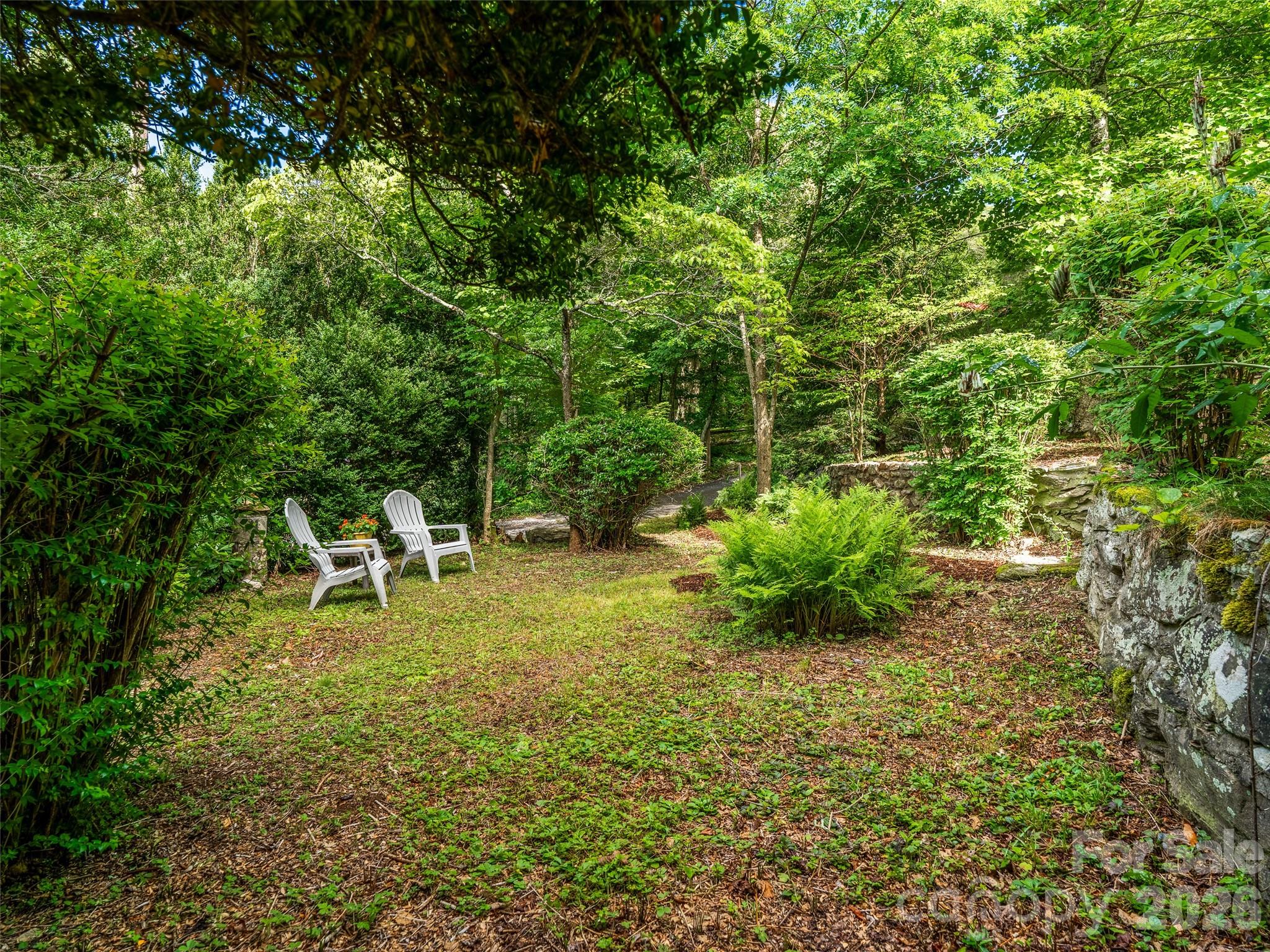 206 Chestnut Hill Road Gerton, NC 28735 - Photo 38 of 48 a garden with a table and chair in the back