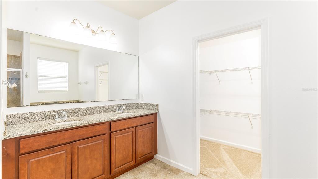1723 Musgrass Circle Melbourne, FL 32904 - Photo 16 of 31 a bathroom with a granite countertop sink and a mirror