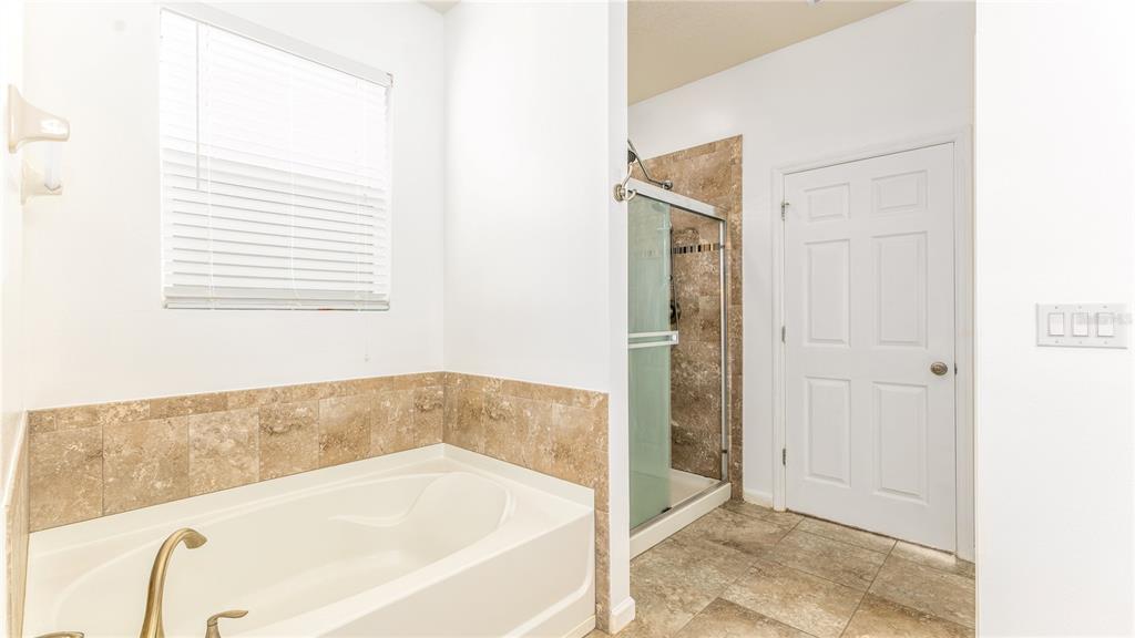1723 Musgrass Circle Melbourne, FL 32904 - Photo 17 of 31 a bathroom with a bathtub and a shower