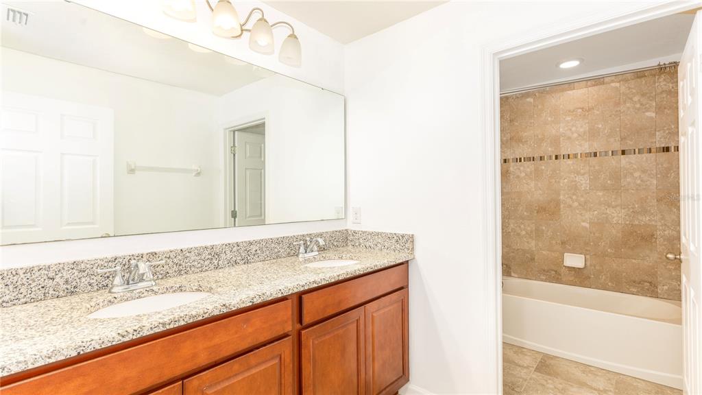 1723 Musgrass Circle Melbourne, FL 32904 - Photo 22 of 31 a bathroom with a granite countertop sink and a mirror