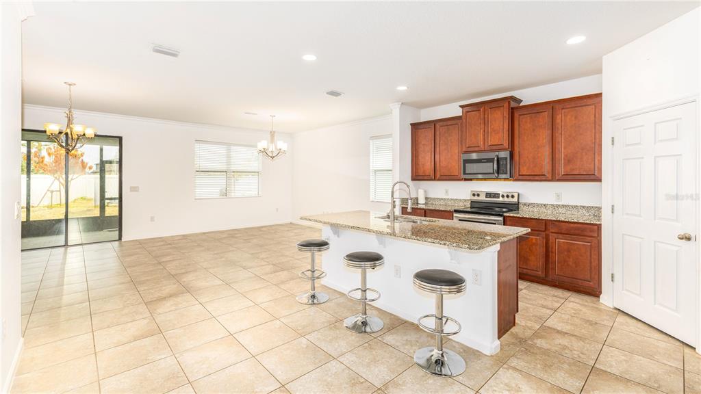 1723 Musgrass Circle Melbourne, FL 32904 - Photo 6 of 31 a kitchen with a sink a stove a microwave and cabinets
