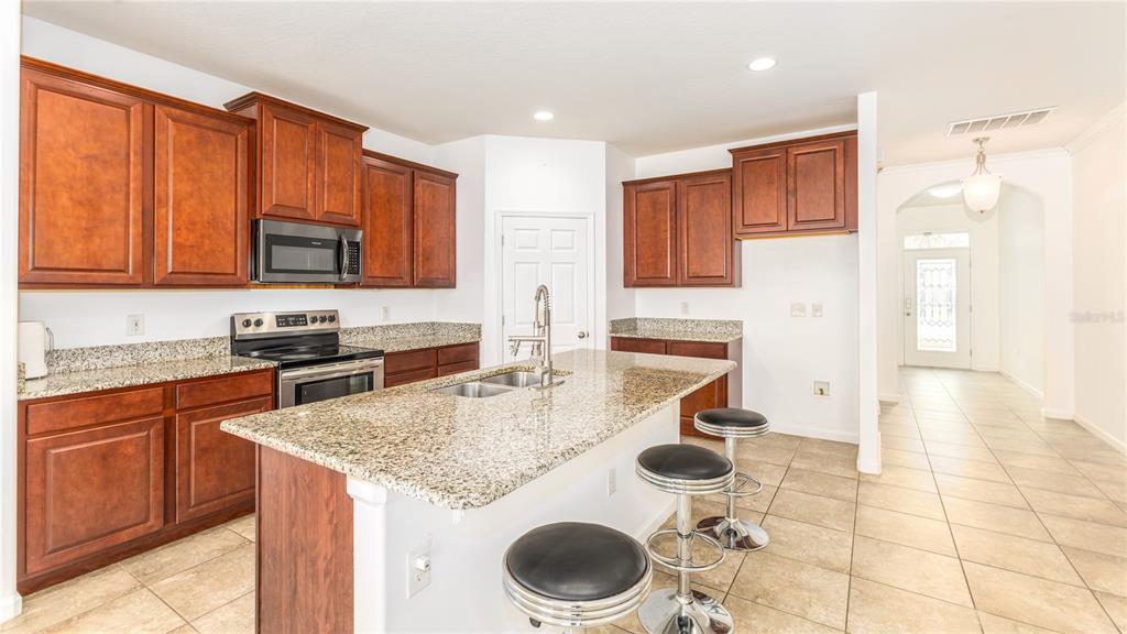 1723 Musgrass Circle Melbourne, FL 32904 - Photo 8 of 31 a kitchen with a sink a stove and cabinets