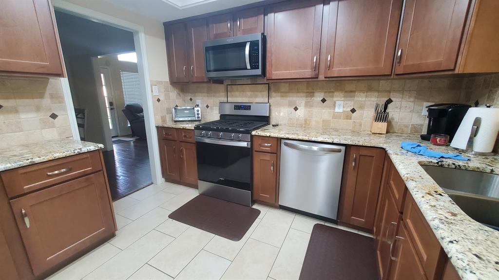 2413 Autumndale Drive Mesquite, TX 75150 - Photo 4 of 14 a kitchen with stainless steel appliances granite countertop a stove a sink and a microwave