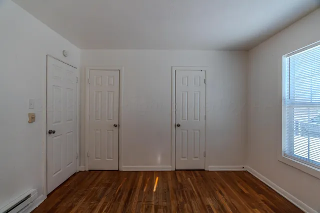 a view of an empty room with closet and a window