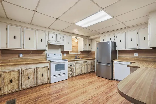 a kitchen with stainless steel appliances a stove refrigerator sink and cabinets