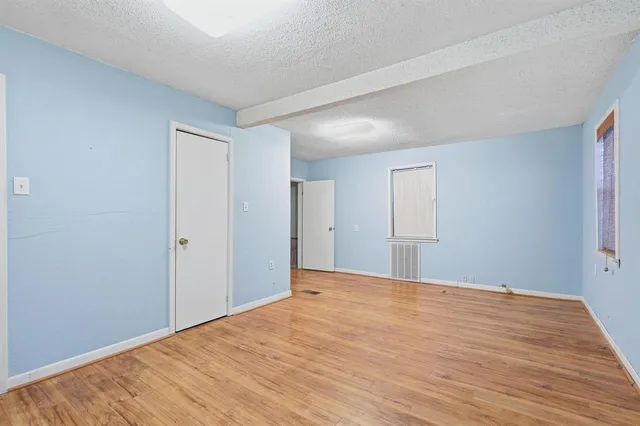 a view of an empty room with wooden floor