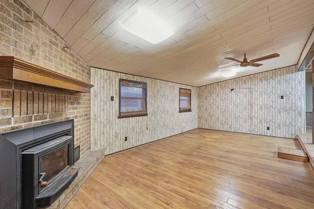 a view of empty room with wooden floor and fireplace