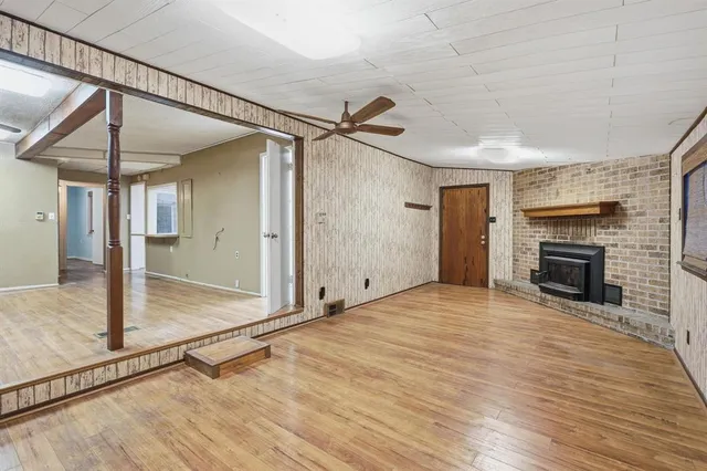 a view of empty room with wooden floor and fireplace