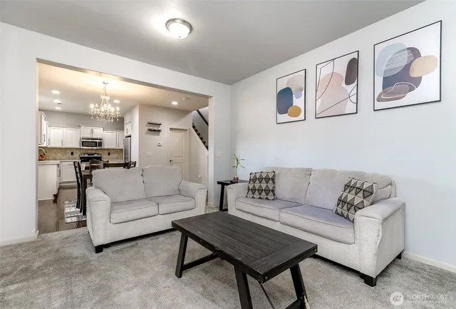 a living room with furniture and a view of kitchen