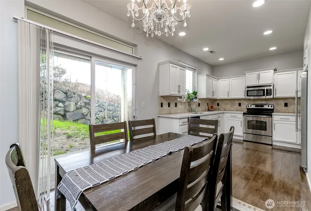 a kitchen with a table chairs microwave and cabinets