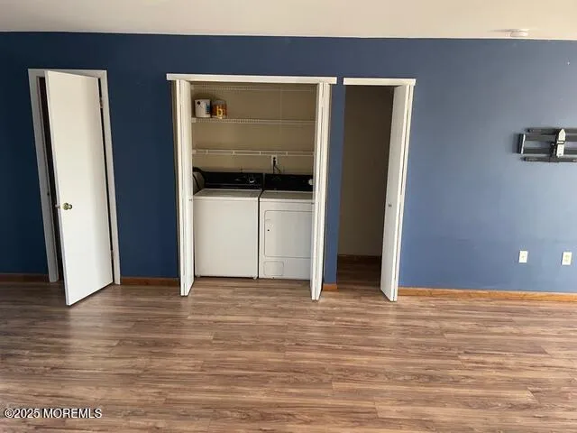 an empty room with wooden floor fireplace and windows
