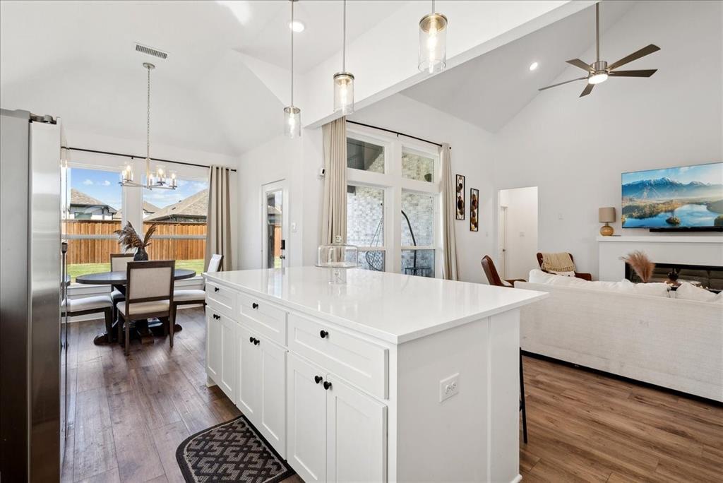 1710 Highwood Road Forney, TX 75126 - Photo 4 of 25 Kitchen island with white cabinetry, a light-toned countertop, and pendant lighting