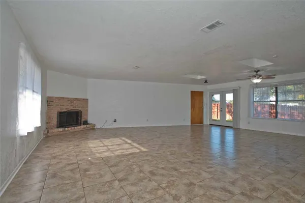 an empty room with fireplace and windows
