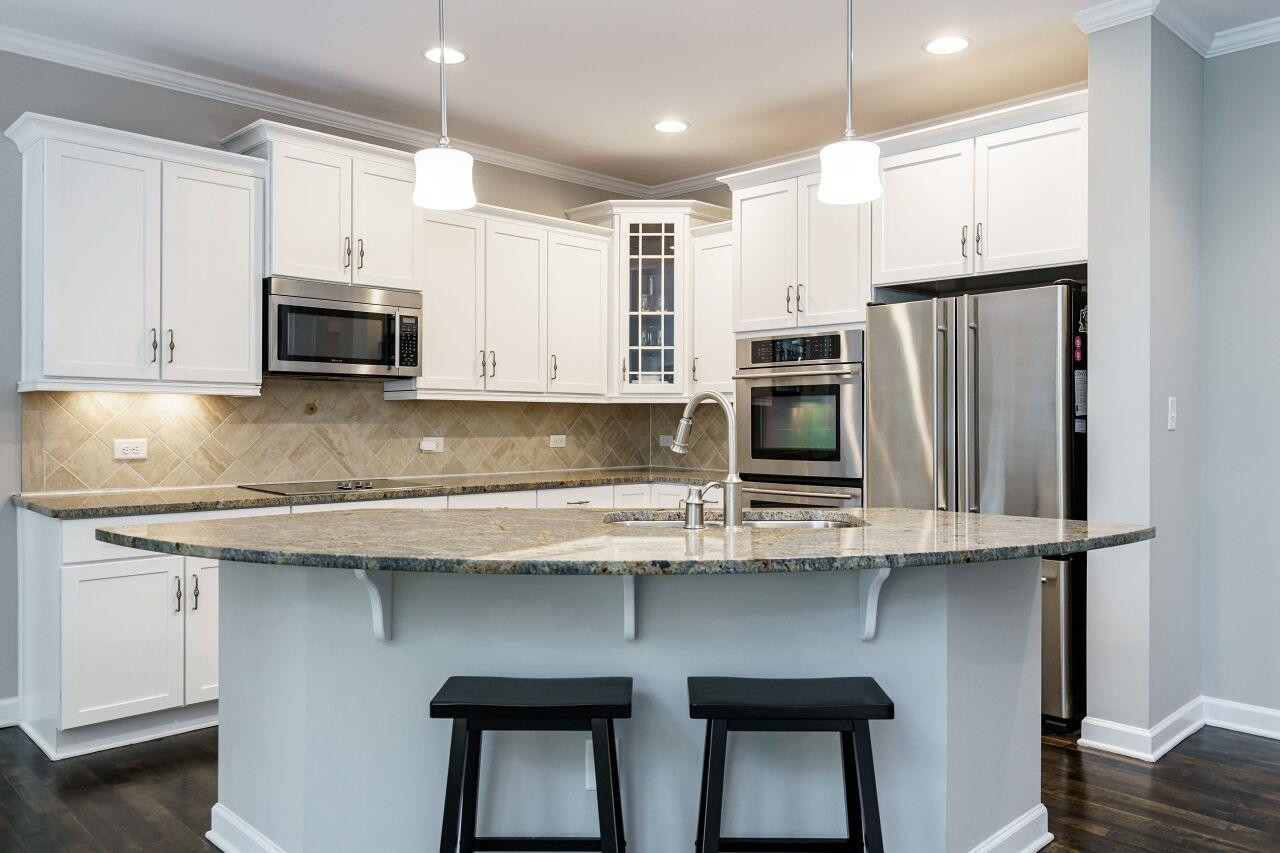 3003 Red Grape Drive Raleigh, NC 27607 - Photo 9 of 35 Stop, this house has it all! Kitchen includes generous granite island, double ovens, stainless appliances, refrigerator, stone backsplash and all in immaculate condition! Kitchen