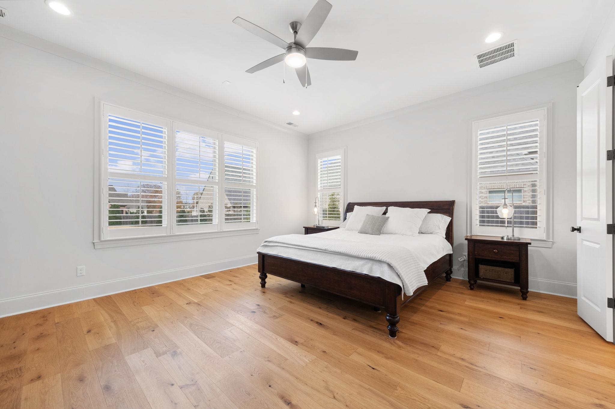 3361 Bailey Station Road Collierville, TN 38017 - Photo 16 of 40 a spacious bedroom with a large bed a chandelier and windows