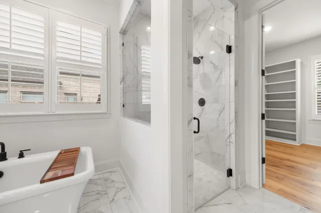 a bathroom with a tub shower and a window