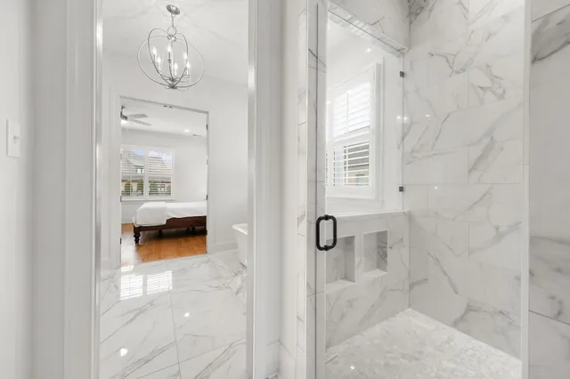 a view of a room that has a bed and a chandelier fan