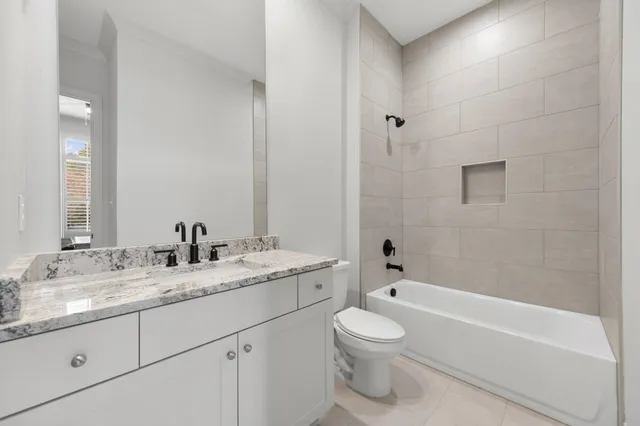 a bathroom with a granite countertop sink a toilet and bathtub