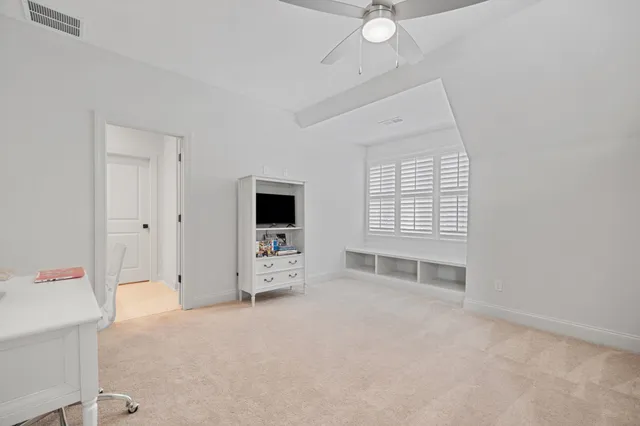 an empty room with cabinet and windows