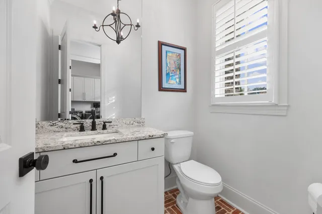 a bathroom with a granite countertop toilet sink and mirror