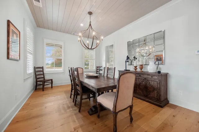 a dining room with furniture a chandelier and window