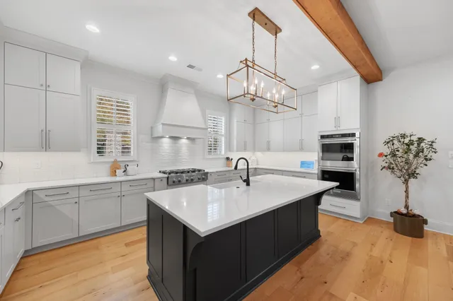 a large kitchen with kitchen island a sink stainless steel appliances and cabinets