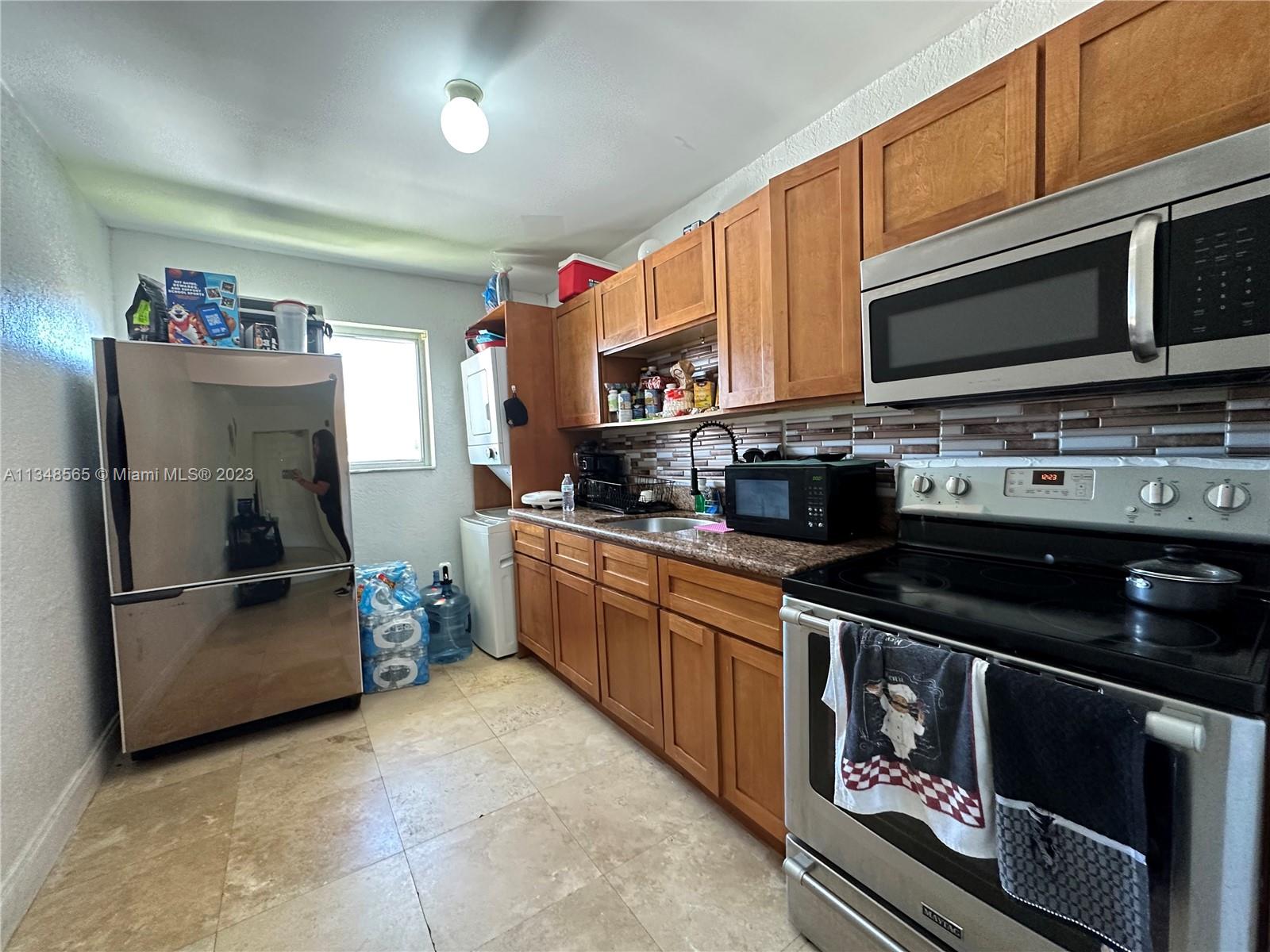 680 Southwest 10th Street, Unit 7 Miami, FL 33130 - Photo 12 of 34 a kitchen with stainless steel appliances a stove a microwave a sink and cabinets
