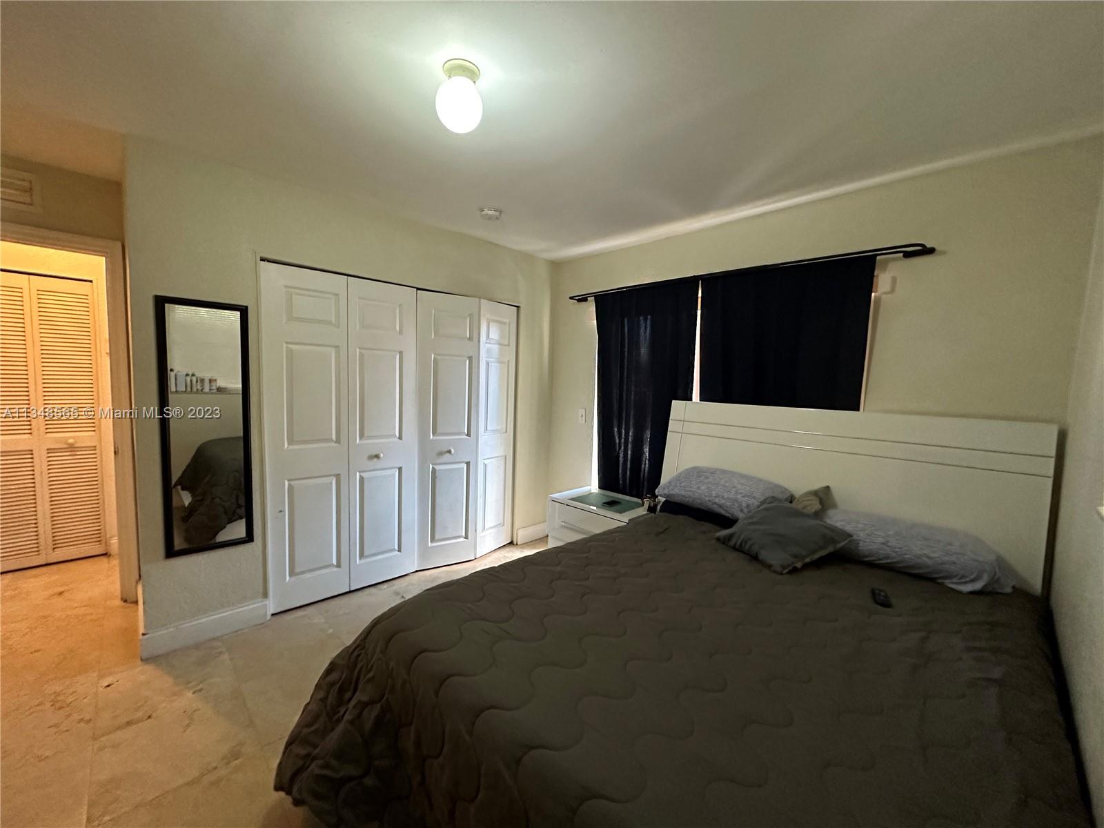 680 Southwest 10th Street, Unit 7 Miami, FL 33130 - Photo 23 of 34 a bedroom with a bed and a walk in closet