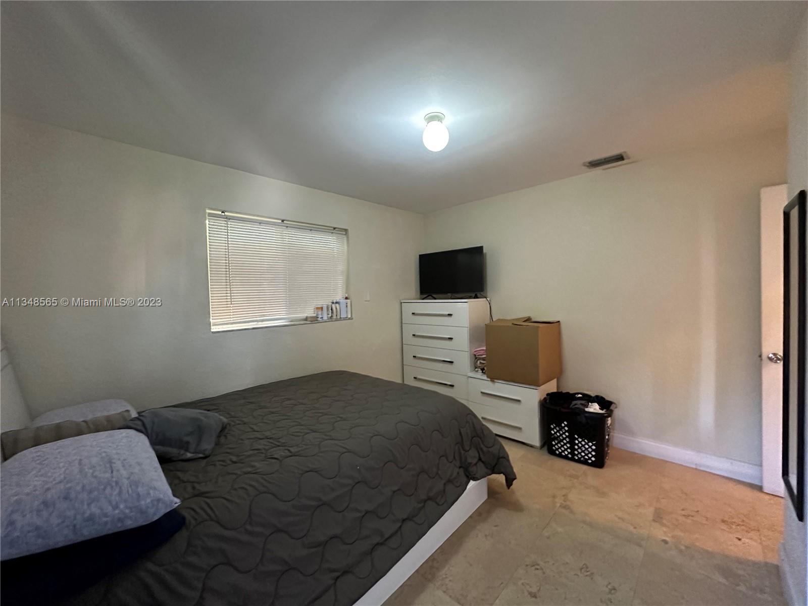 680 Southwest 10th Street, Unit 7 Miami, FL 33130 - Photo 25 of 34 a bedroom with a bed and a tv on the dresser