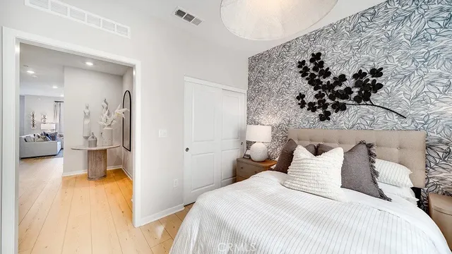 a bedroom with a large bed and a view of living room