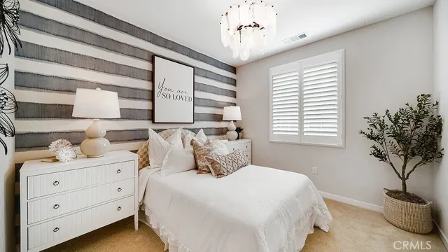 a bedroom with a large bed and a potted plant